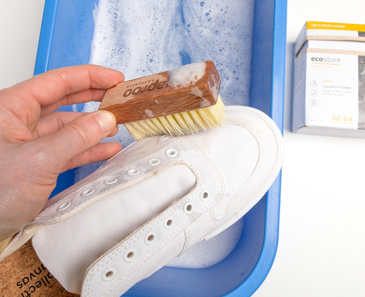 White Collective Canvas sneaker being scrubbed with soapy water.