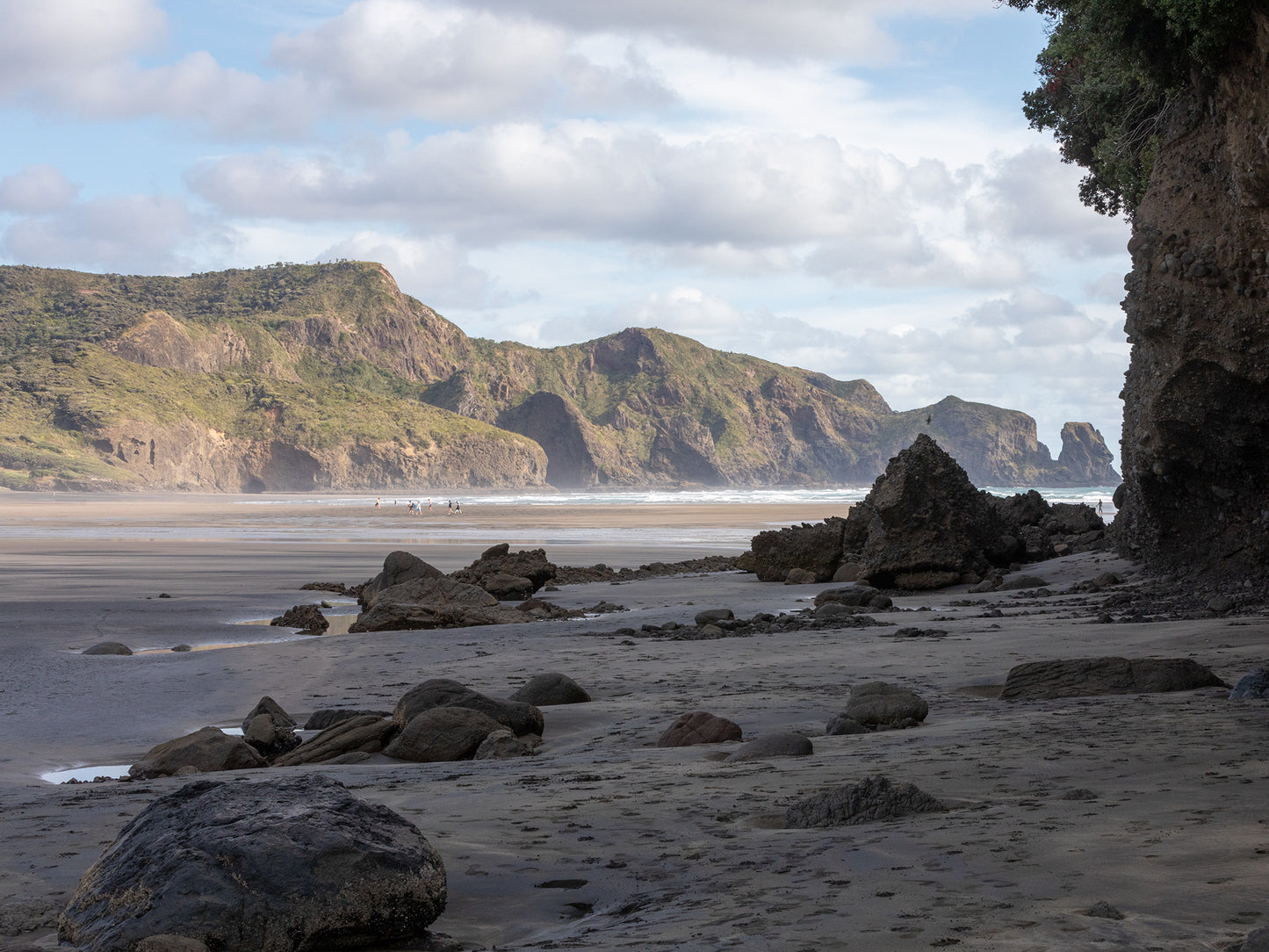 Photograph of beach with green hills in distant.