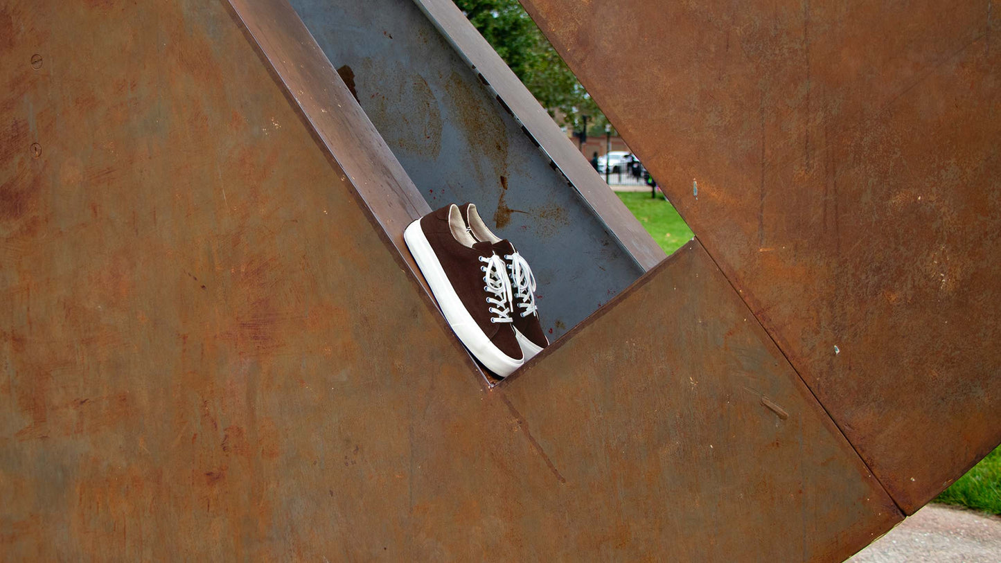 Collective Canvas brown shoe on rusty sculpture.